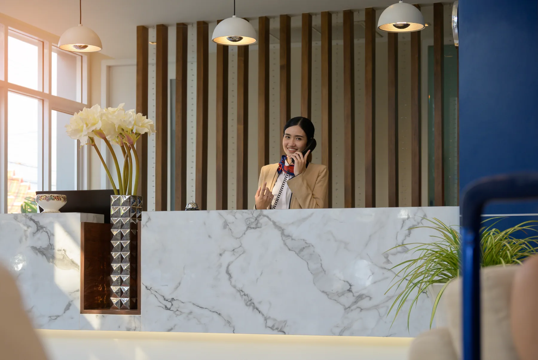 A receptionist on a call at a marble desk